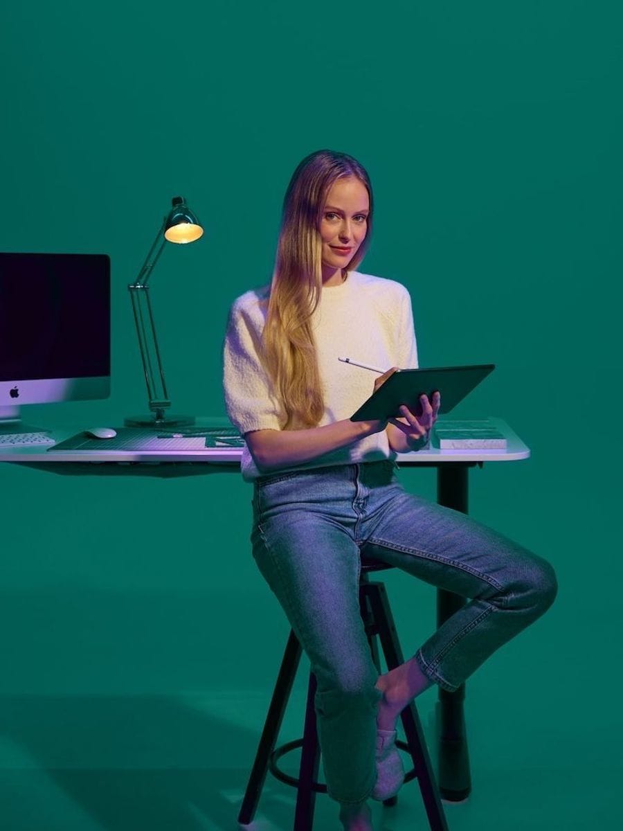 Arkitekt situr við skrifborð og hannar á iPad Pro með Apple penna