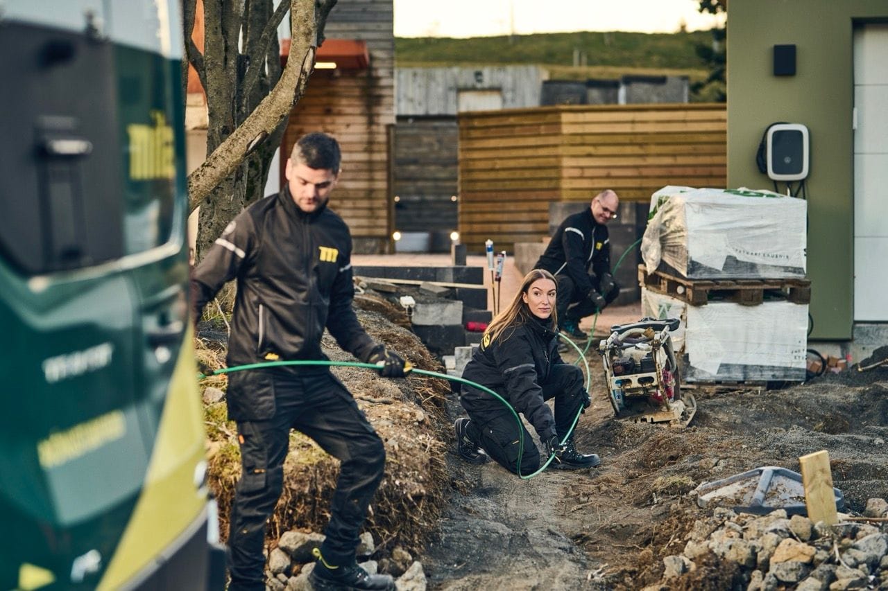Starfsfólk Mílu leggur ljósleiðara í skurð.