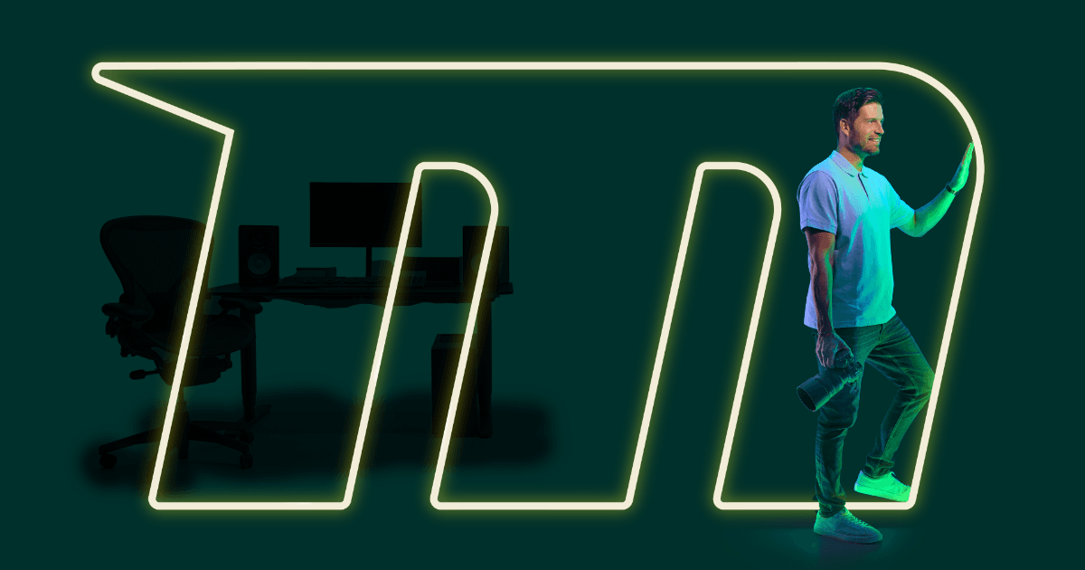 Ljósmyndari stígur út úr merki Mílu með skrifborð í bakgrunni